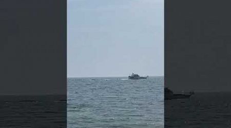 Cruiser Yacht moving along a sunny shoreline 