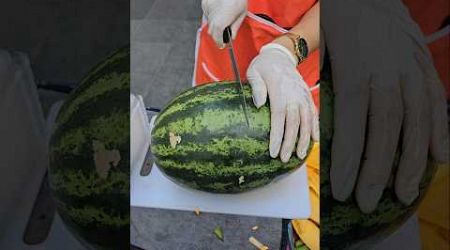 It is on the street in Bangkok. The watermelon is neatly cut and sold on the spot