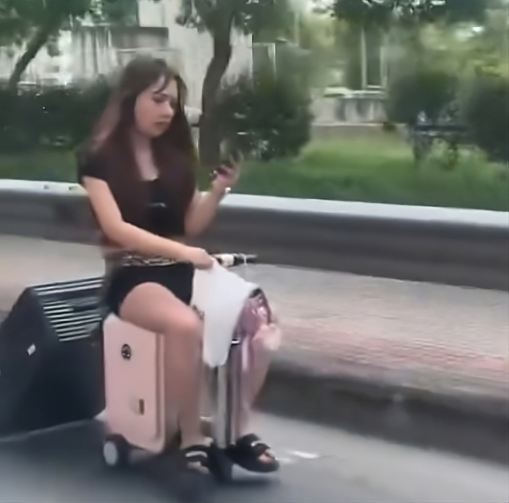 Unbelievable or Genius? Woman Hops on Suitcase for a Wild Ride Through Busy Bangkok To Catch Her Flight!